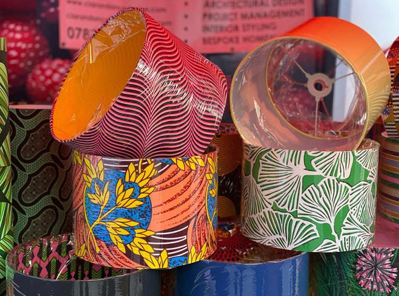 Collection of pink, orange, yellow blue & green Ankara fabric covered, double-sided drum lampshades including 'Blue Moon', 'Gingko Paradise', 'In the Clouds' & 'Light as a Feather'